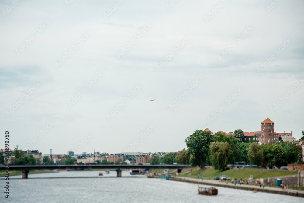 The river flows through the city. Church on the hill above the river. Wisla River in Krakow. Float the boat and the ship under water
