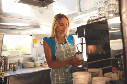 Female waiter preparing coffee in food truck