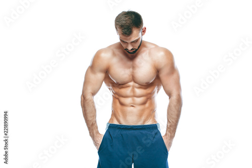 bodybuilder posing. Beautiful sporty guy male power. Fitness muscled in blue shorts. on isolated white background. Man with muscular torso. Strong Athletic Man Fitness Model Torso showing six pack abs © satyrenko