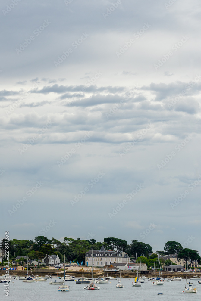 vue verticale sur des battisses au bord de la mer en Bretagne avec des bateaux sur l'eau