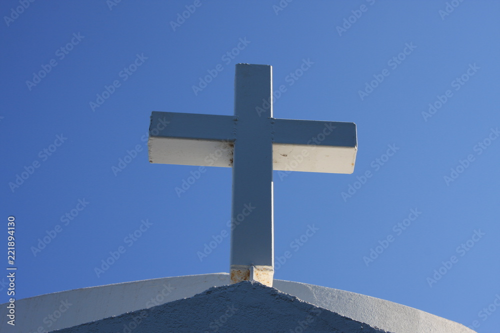 Cycladic greek orthodox church on Paros island, Greece. White cross against blue sky