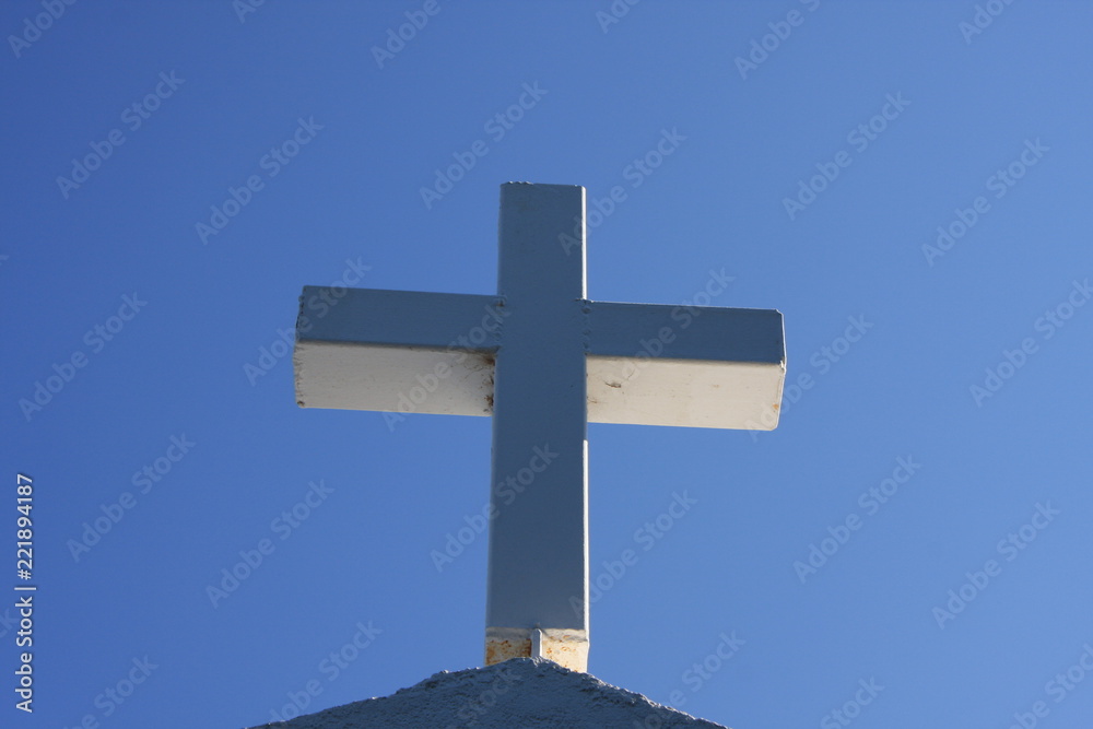 Cycladic greek orthodox church on Paros island, Greece. White cross against blue sky