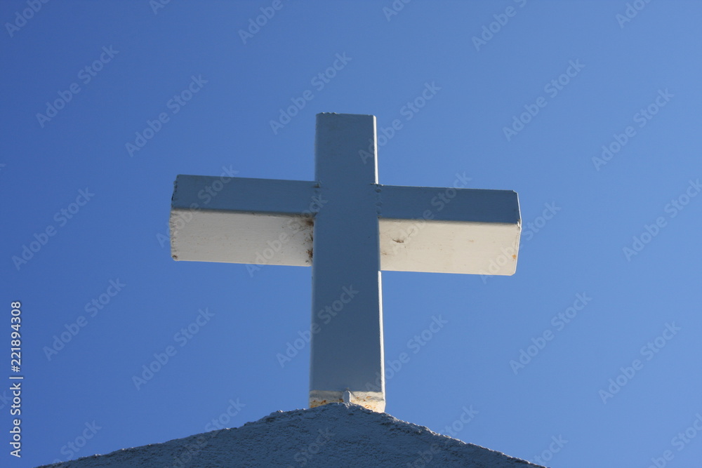 Cycladic greek orthodox church on Paros island, Greece. White cross against blue sky