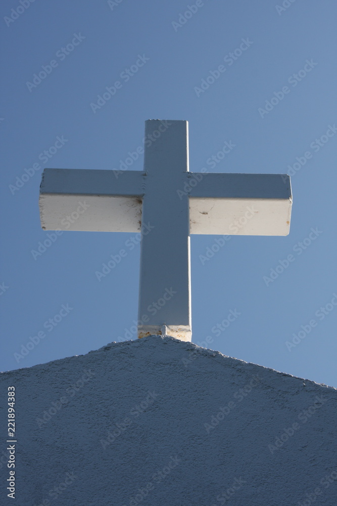 Cycladic greek orthodox church on Paros island, Greece. White cross against blue sky