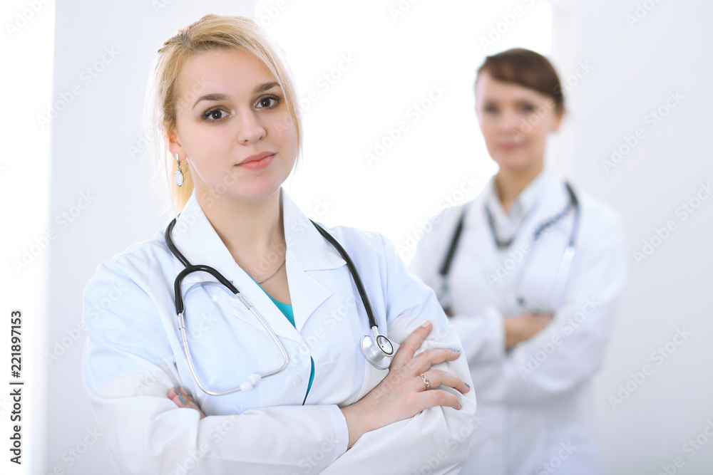 Female doctor standing with arms crossed in hospital. Medicine and health care concept Female doctor standing with arms crossed in hospital. Medicine and health care concept