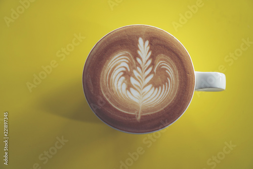 latte art on yellow cafe ta...