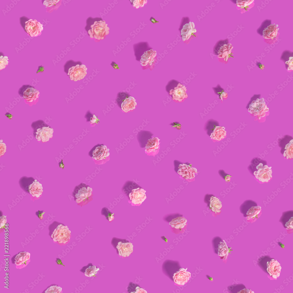 Minimalistic seamless pattern of over 50 different cropped roses, in many hues, studio photographed over reflecting background and isolated on absolute pink color and long shadows