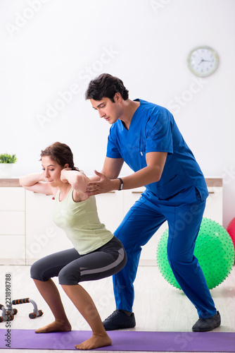 Fitness instructor helping sportsman during exercise