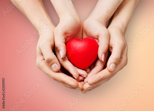 Red Heart in hands, close-up view