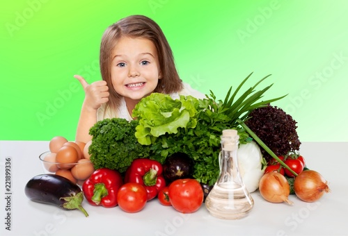 Beautiful girl with colored vegetables showing thumbs