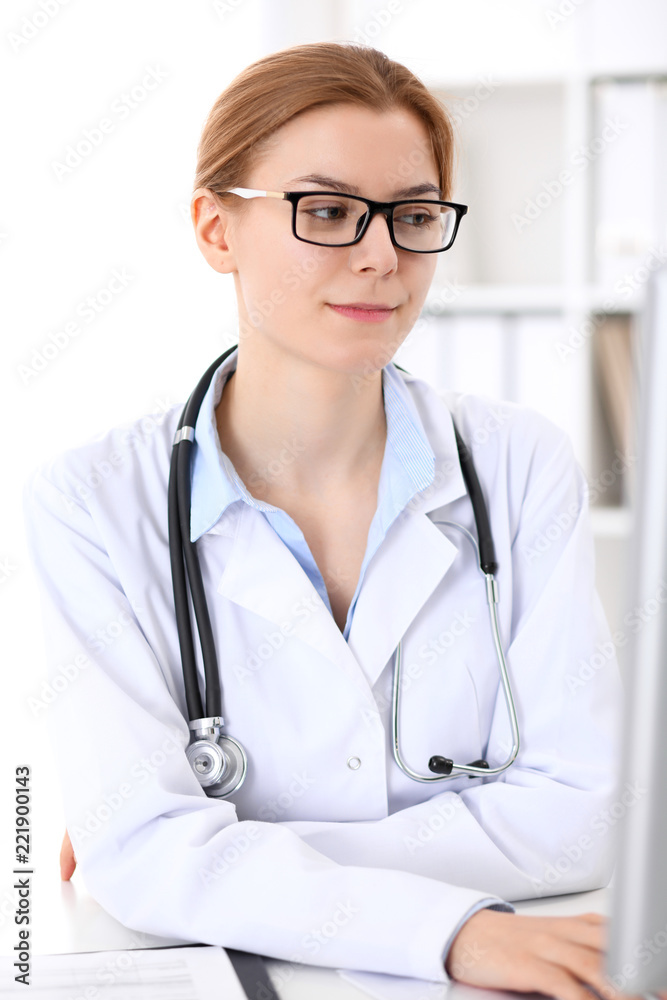 Young brunette female doctor at work in hospital. Physician ready to help. Medicine and healthcare concept Young brunette female doctor at work in hospital. Physician ready to help. Medicine and healthcare concept