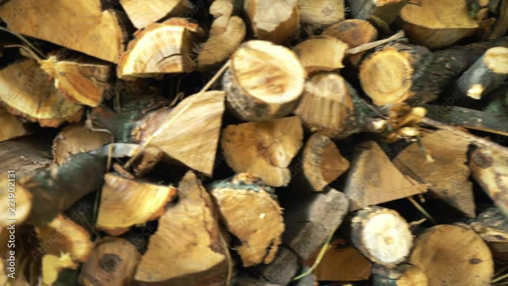 The sawn and chopped wood, folded next to the wall. preparation of wood for the fireplace. wood storage for winter. firewood of round and triangular shape The sawn and chopped wood, folded next to the wall. preparation of wood for the fireplace. wood storage for winter. firewood of round and triangular shape