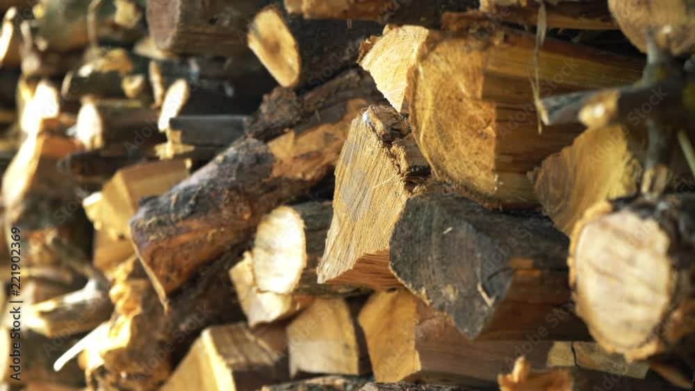 The sawn and chopped wood, folded next to the wall. preparation of wood for the fireplace. wood storage for winter. firewood of round and triangular shape The sawn and chopped wood, folded next to the wall. preparation of wood for the fireplace. wood storage for winter. firewood of round and triangular shape