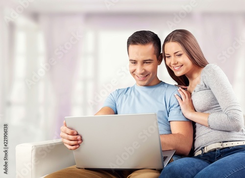 Young business couple using laptop at home, online shopping with