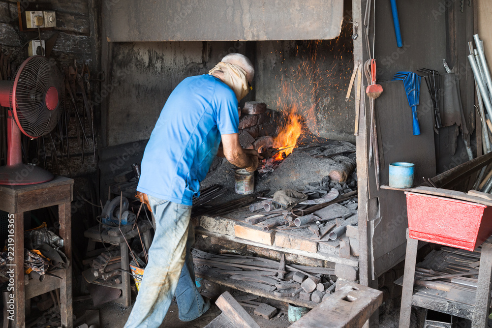 Blacksmith at work in small workshop in Malaysia Blacksmith at work in small workshop in Malaysia