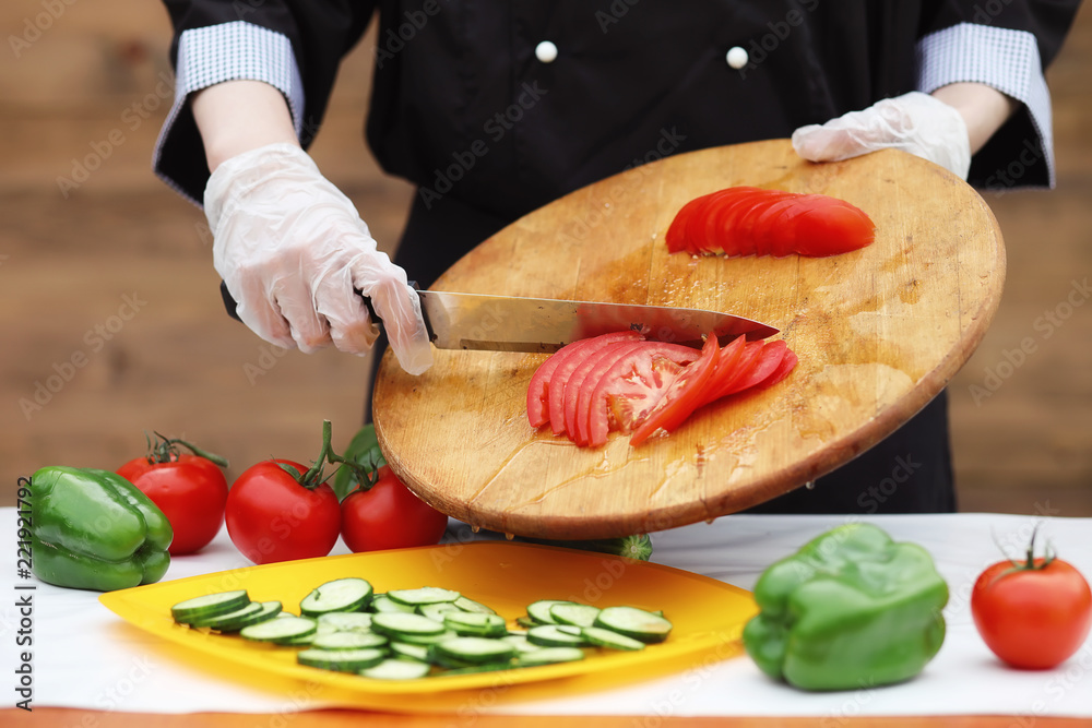 The cook cuts fresh farm vegetables