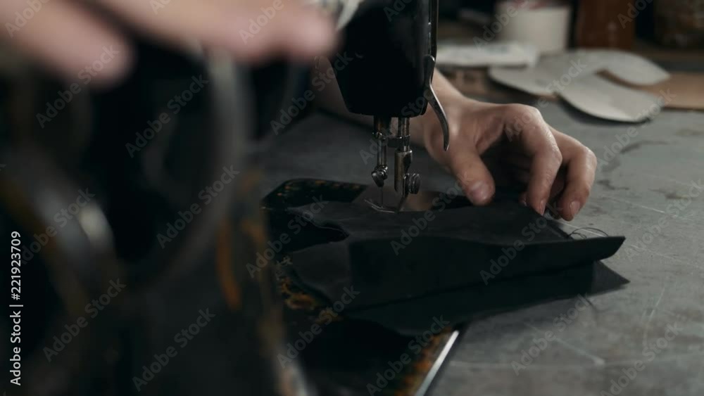 Sewing process of the leather shoes production factory bag belt. Man's hands behind sewing. Leather workshop handmade diy shoemaker