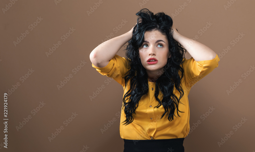 Young woman feeling stressed on a solid background Young woman feeling stressed on a solid background