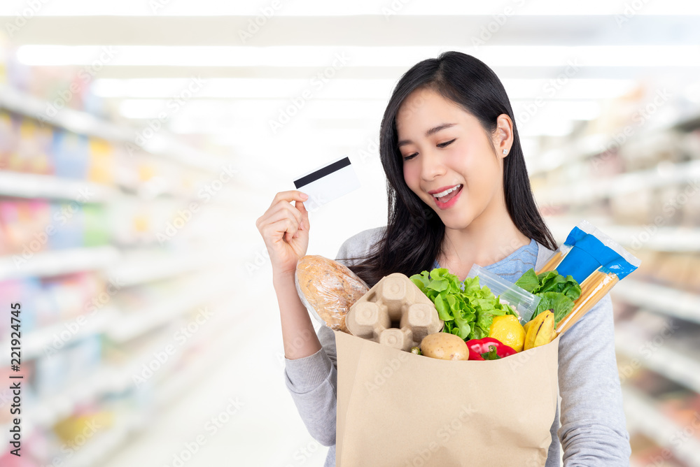 Beautiful Asian woman shopping groceries with credit card in supermarket Beautiful Asian woman shopping groceries with credit card in supermarket