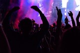 Crowd at a concert under purple lights of stage. Radial blur effect creates a strong sense of emotion and involvement in the scene