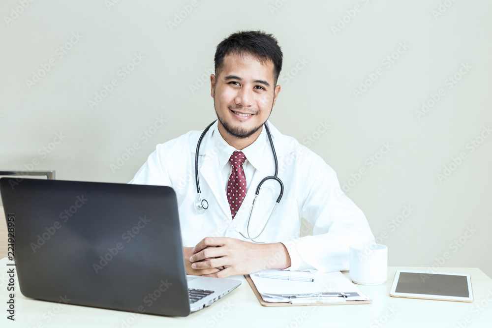 Doctor sitting on work table and smile with service mind and positive emotional Doctor sitting on work table and smile with service mind and positive emotional
