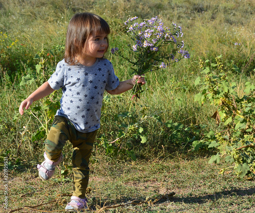 little girl runs on meddow photo