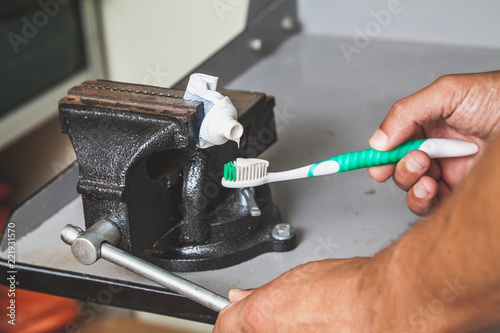 squeezes toothpaste from tube with vise photo