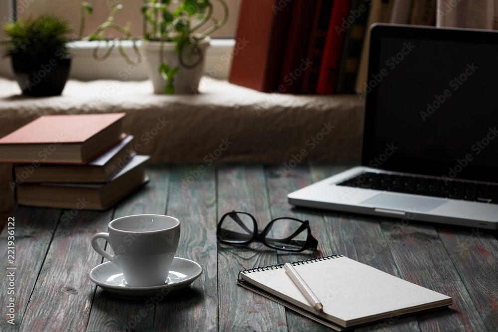 A cup of coffee in the workplace on a wooden table.