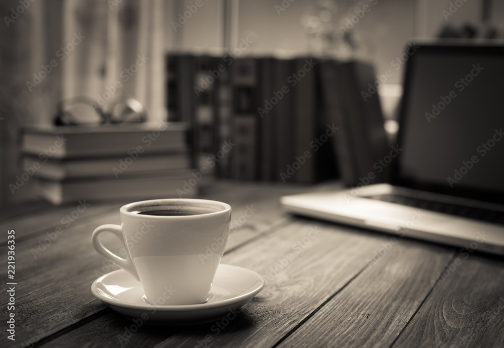 A cup of coffee in the workplace on a wooden table. A cup of coffee in the workplace on a wooden table.