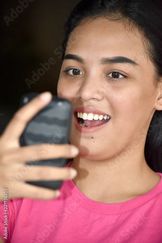 Female Using Cell Phone And Happy