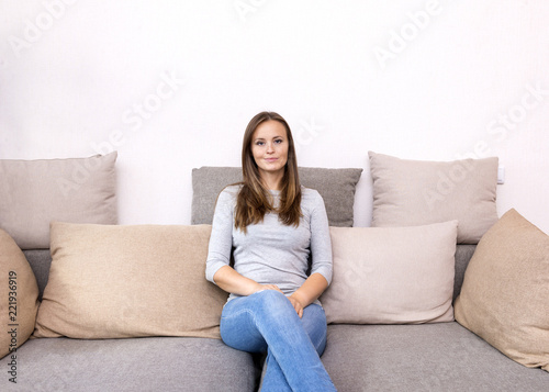 1 white young woman sitting on sofa