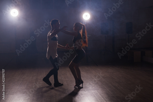 Young couple dancing social danse kizomba or bachata or semba or taraxia in dancing class background © satura_