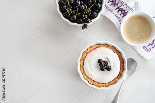 Delicious tart decorated with burned merengue and berries, served in white composition, with copy space. Top view.