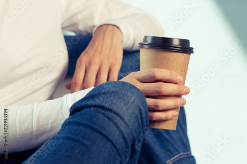 Young woman in white shirt with disposable coffee cup. Youth, modern lifestyle. Coffee break, cosy relaxing moment. 