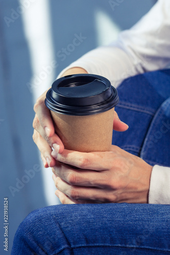 Young woman in white shirt with disposable coffee cup. Youth, modern lifestyle. Coffee break, cosy relaxing moment. 