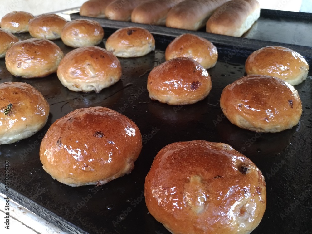 Fresh pastry, round buns on a roasting pan