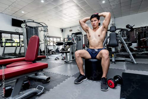 Handsome Attractive Asian men work out with dumbbell in gym for build muscle and strong body,feeling so strong and powerful,Bodybuilder Concept