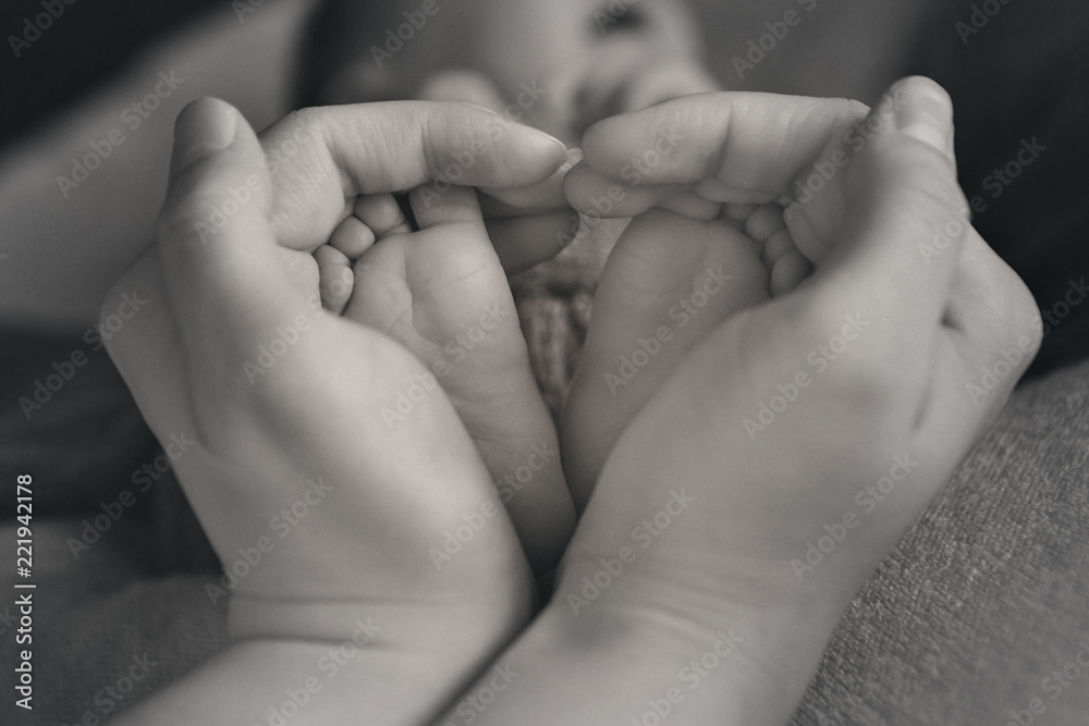 Newborn Baby's feet. Mother and father holding newborn baby legs,legs massage