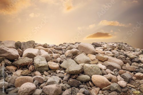 Many small and big stones on ground against sunset