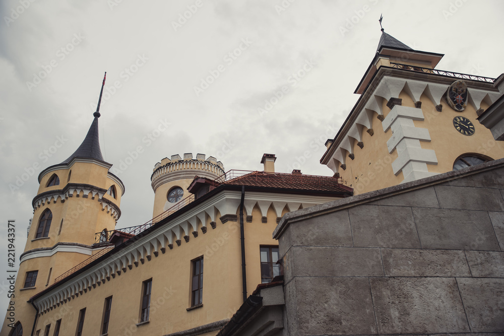 Yellow castle with brown roof in cloudy weather
