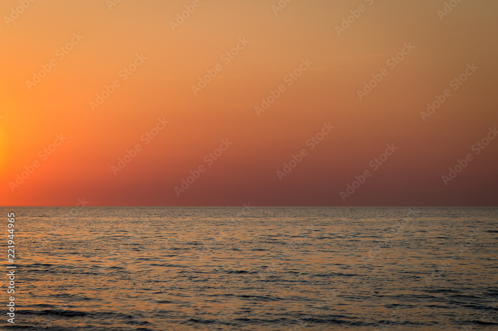 Sunset over sea with bright orange sky