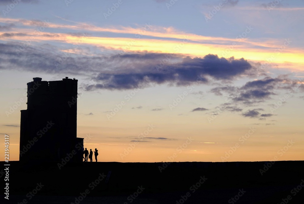 Tower, sunset and cliffs of Moher
