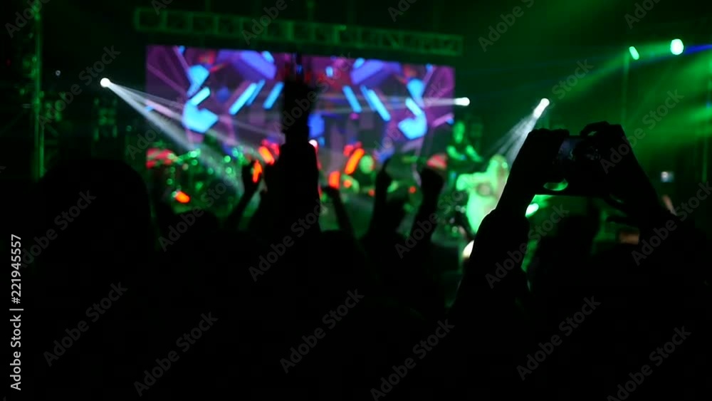 Cheering crowd fan spectators audience enjoying a music raising hands in lumiere