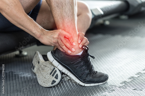 Asian man injury ankle pain after training running workout in gym feeling so pain,Healthcare Concept photo
