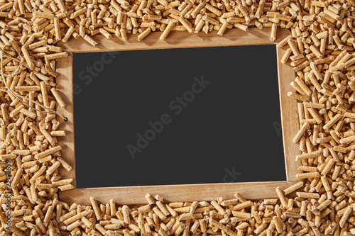 Fotografi Vintage school slate surrounded by wood pellets