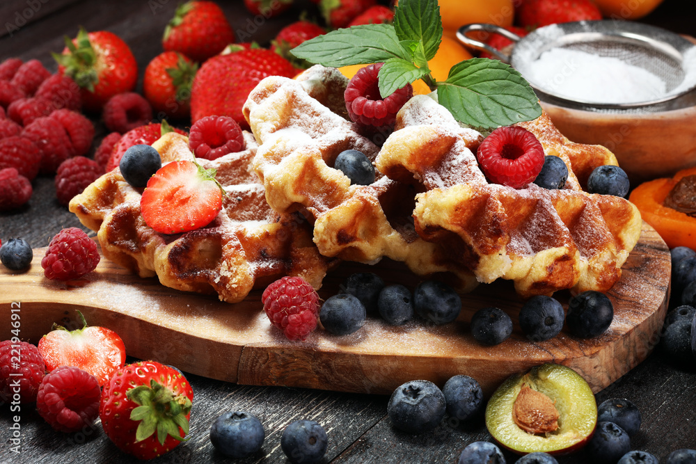 Traditional belgian waffles with fresh mint, sugar and raspberries. Traditional belgian waffles with fresh mint, sugar and raspberries.