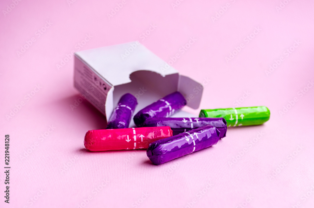 white box with multi-colored tampons on a pink background Stock Photo | Adobe