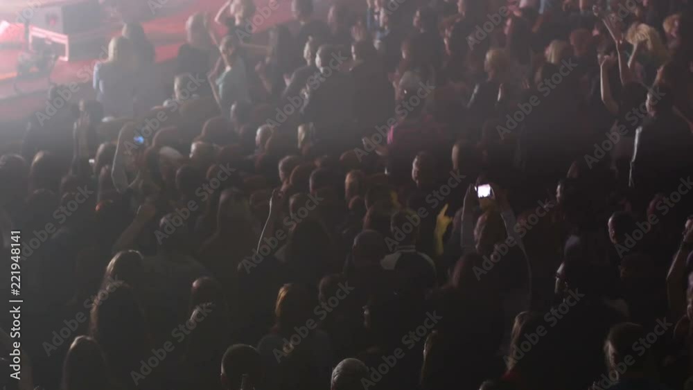 Crowd people dancing enjoying a music concert stroboscope lumiere lights