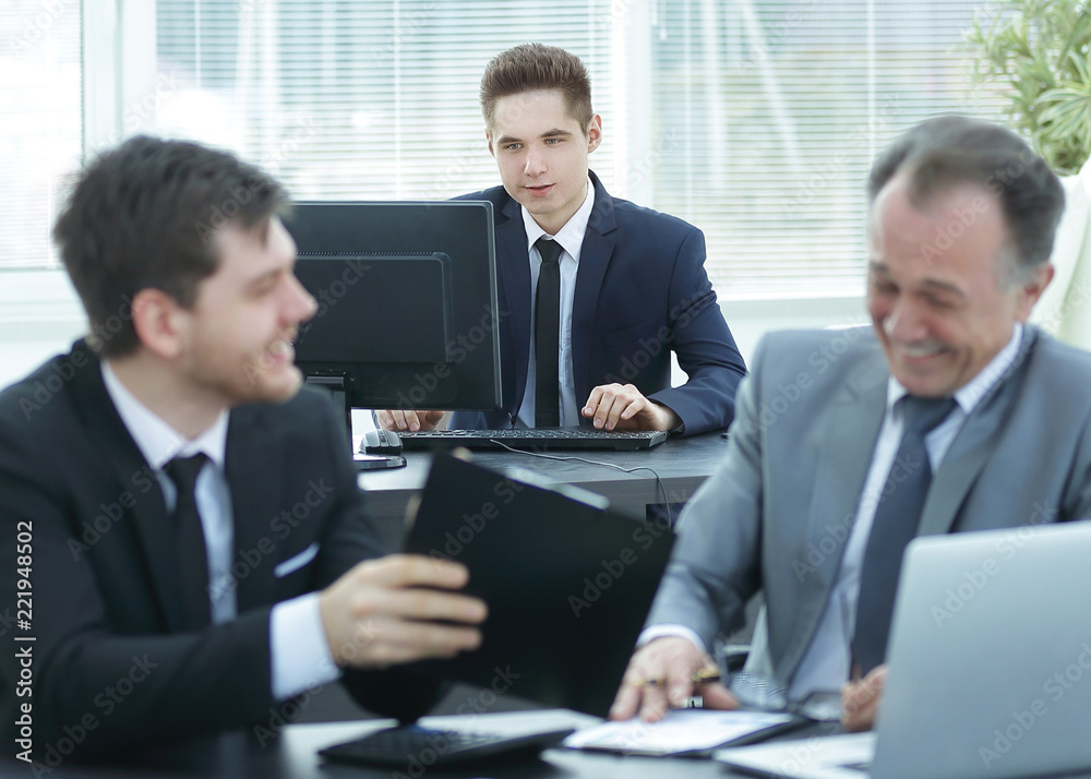 boss and employee discussing the document sitting at the Desk in the office. boss and employee discussing the document sitting at the Desk in the office.