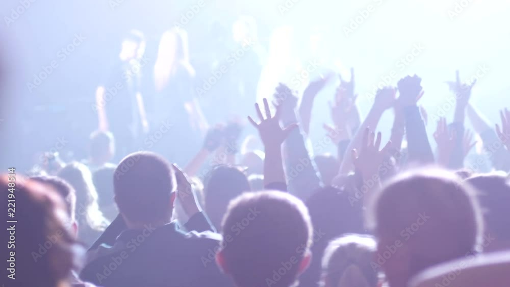 Crowd people spectators at concert raise hands up enjoying a music in lumiere